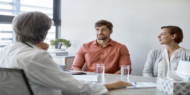A person in a red shirt sitting at a table with a person in a white shirt AI-generated content may be incorrect.