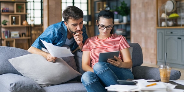 A person and person sitting on a couch looking at a tablet AI-generated content may be incorrect.