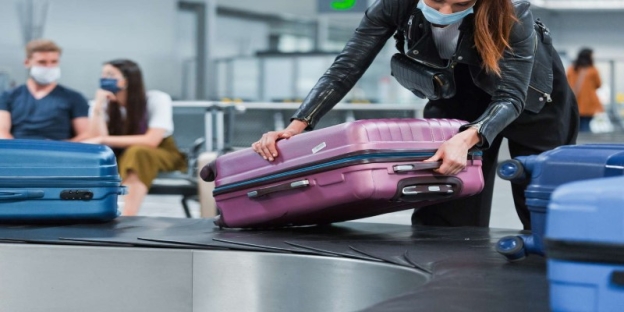 A person holding a suitcase AI-generated content may be incorrect.